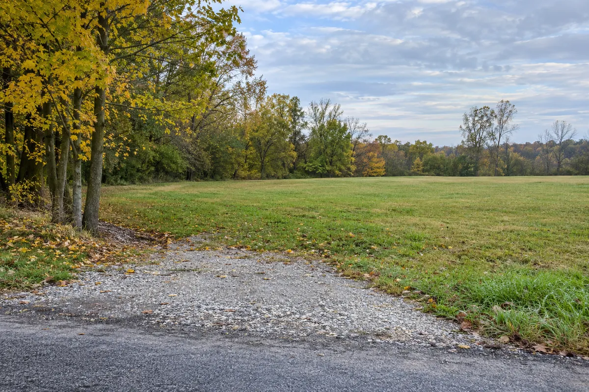 Level northeastern Ohio meadow beside autumn trees with a gravel entrance